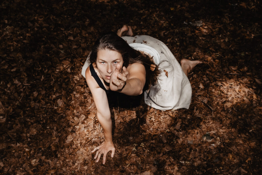 Soul Photography einer Frau in der Natur auf einem von Laub besetzten Waldboden.