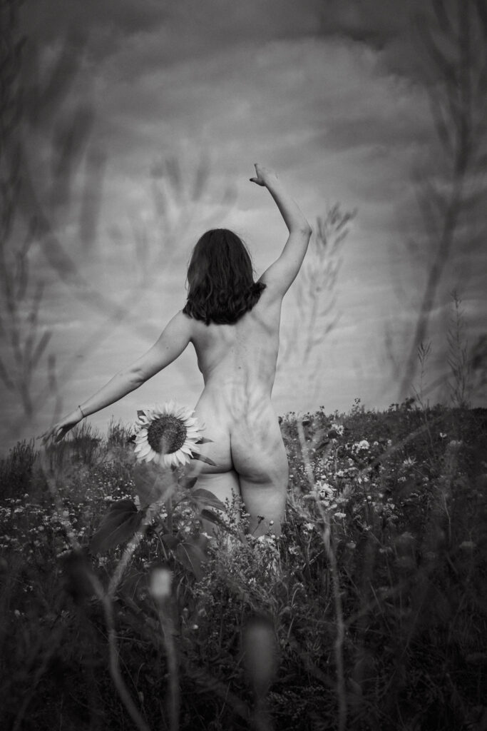 Sinnliche Seelenfotografie mit einer Frau in einer Blumenwiese mit Seelenfotografin.